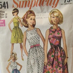 May include: A vintage sewing pattern for a sleeveless dress with a collar. The pattern is for sizes 12 and 34 bust. The pattern is from Simplicity and has a floral print.