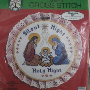 May include: A complete cross stitch kit featuring a nativity scene with the text "Silent Night" and "Holy Night". The kit includes everything needed to complete the project, including fabric, floss, and instructions. The finished size is 10 inches.