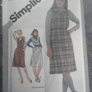 May include: A Simplicity sewing pattern for a plaid jumper dress. The pattern is for sizes H (58789) Junior. The pattern includes three sizes and is available in sizes H (56769), (789811); 0 (11613815). The pattern instructions state that if combining sizes, buy fabric for the largest size you plan to use.
