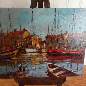May include: A painting of a harbor scene with several boats docked. The boats are painted in shades of red, yellow, and blue. The water is a light blue and there are buildings in the background.