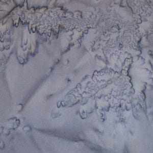 Könnte beinhalten: Eine weiße Keramik-Tasse mit schwarzem Henkel und dem Text "But First, Coffee" in fetter, schwarzer Schrift. Die Tasse steht vor einem verschwommenen Hintergrund, der eine gemütliche Umgebung suggeriert.