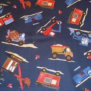 Peut inclure: Un tissu bleu avec un motif répété de différents véhicules de chantier. Les véhicules sont rouges, jaunes, bleus et bruns. Les véhicules comprennent un camion à benne basculante, une bétonnière, une grue, une pelle rétrocaveuse et un camion à plateau.