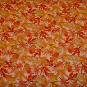 Peut inclure: Un motif de tissu sans couture avec un motif répétitif de feuilles orange, jaunes et brunes sur un fond rose clair.