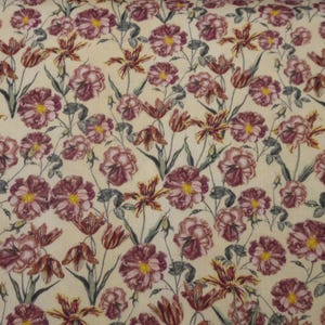 May include: A fabric with a repeating floral pattern. The design features various flowers in shades of burgundy, pink, and yellow, set against a cream-coloured background. The flowers are accompanied by green stems and leaves, creating a botanical theme.
