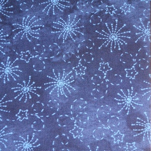 Op de afbeelding: Blauwe stof met een wit vuurwerk- en sterrenpatroon. De stof is getextureerd en heeft een subtiele glans.