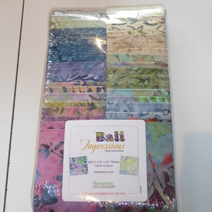 May include: A pack of 40 fabric strips for quilting. The strips are 2 1/2 inches wide and 42 inches long. The fabric is 100% cotton and is triple dyed batik. The fabric is a variety of colours, including pink, green, blue, and purple. The pack is labelled "Bali Impressions" and "Benartex".