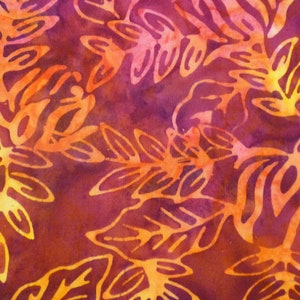 May include: A close-up of a fabric with a repeating pattern of orange and yellow leaves on a deep red background. The leaves are stylised and have a batik-like appearance.