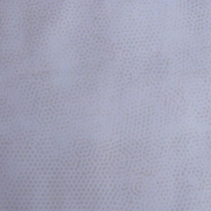 Könnte beinhalten: Nahaufnahme eines hellgrauen Stoffes mit einem dezenten Muster aus kleinen, hellbraunen Punkten.
