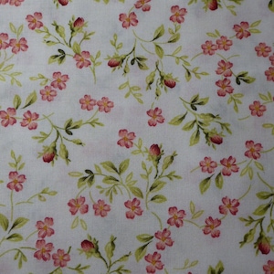 Könnte beinhalten: Nahaufnahme eines weißen Stoffes mit floralem Muster. Das Muster zeigt kleine rosa Blüten mit gelben Zentren und grüne Blätter. Die Blüten und Blätter sind durch dünne grüne Stiele verbunden.