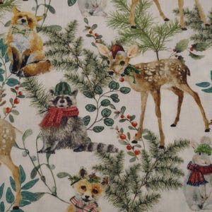Peut inclure: Un motif de tissu festif représentant des animaux de la forêt dans un cadre hivernal. Le motif comprend des renards, des cerfs, des ratons laveurs et des lapins, tous portant des accessoires d'hiver. Le motif est orné de feuillage vert et de baies rouges.