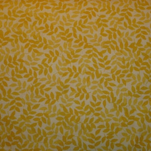 May include: A yellow fabric with a repeating pattern of small, stylized leaves.