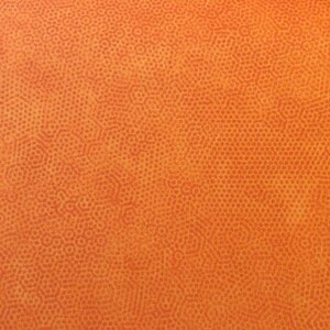 Könnte beinhalten: Orangener Stoff mit einem strukturierten Muster aus kleinen, sich wiederholenden Kreisen.