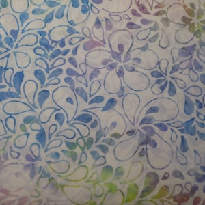 May include: A white fabric with a blue and purple floral pattern. The pattern is made up of small, teardrop-shaped leaves and flowers.