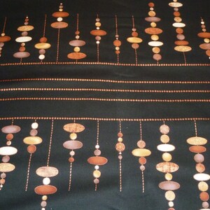 May include: Black fabric with a repeating pattern of brown and tan oval shapes connected by vertical lines. The design includes horizontal rows of small, copper-colored dots and solid copper-colored lines. The overall aesthetic is reminiscent of a retro or mid-century modern style.