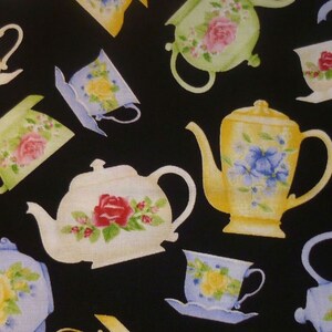 Könnte beinhalten: Schwarzer Stoff mit einem sich wiederholenden Muster aus Teetassen, Teekannen und Untertassen. Die Teetassen und Teekannen sind in Pastellfarben gehalten, darunter Gelb, Grün und Blau, und mit floralen Designs verziert.