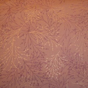 Può includere: Primo piano di un tessuto con un motivo ripetitivo di delicati rami di colore marrone chiaro su uno sfondo rosa polveroso.