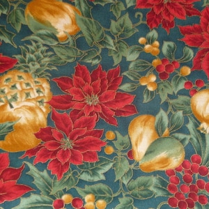 Op de afbeelding: Een teal stof met een herhalend patroon van rode kerststerren, ananas, peren en rode bessen. De stof heeft een gouden metallic glans.