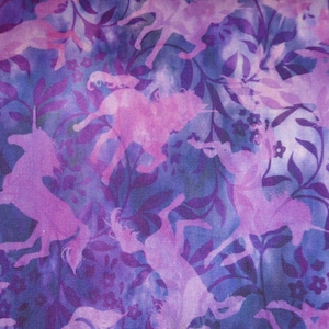 Puede incluir: Tela morada con un patrón repetido de siluetas de unicornios rosas sobre un fondo azul.