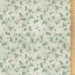 Könnte beinhalten: Ein Stoff mit einem sich wiederholenden Muster aus weißen Blüten, grünen Tannennadeln und kleinen blauen Beeren auf hellgrünem Hintergrund. Ein Lineal mit Zentimetermessungen ist sichtbar.