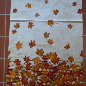 Peut inclure: Tissu crème avec un motif de feuilles d'automne tombantes. Les feuilles sont de couleurs rouge, orange et jaune. Le bas du tissu présente un amas dense de feuilles.