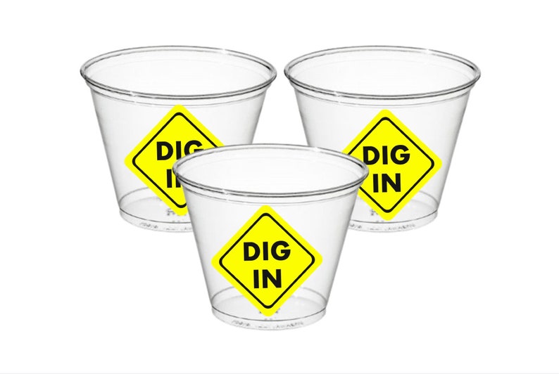 May include: Three clear plastic cups with yellow diamond-shaped stickers that say "DIG IN" in black letters.