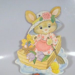 Decoración de Pascua vintage en cartón troquelado: conejo con sombrero en un bote de remos