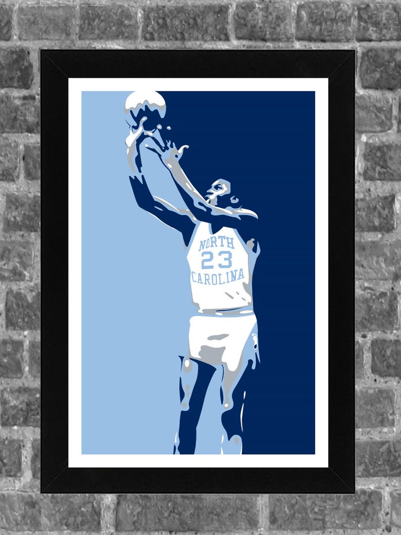 May include: A blue and white basketball poster featuring a player in a white jersey with the text "NORTH 23 CAROLINA" on the front. The player is jumping in the air and shooting a basketball.