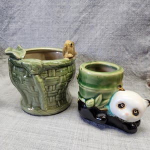 May include: Two ceramic planters. One is green and shaped like a basket with a frog figurine. The other is green and shaped like bamboo, with a panda bear figurine. Both planters have a glossy finish.