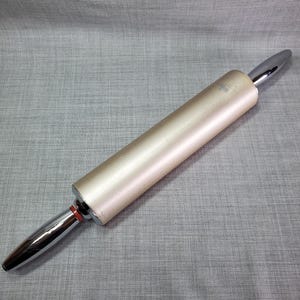 May include: A gold-colored rolling pin with chrome-plated ends. The rolling pin is approximately 17 inches long.