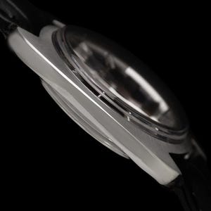May include: Close-up of a silver wristwatch with a black leather band. The watch has a clear, domed crystal and a sleek, metallic case. The image is set against a black background, highlighting the watch's design. The text "CONNOISSEUROFTIME" is visible.