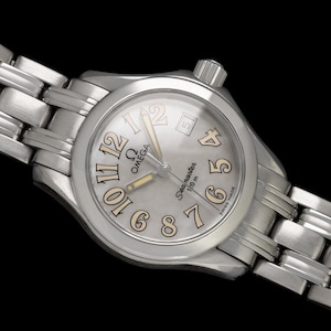 May include: Silver-toned Omega Seamaster wristwatch with a light gray face and a stainless steel band. The watch face features beige numerals and hands, with the Omega logo and "Seamaster 150 m" text.