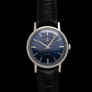 May include: A vintage wristwatch with a dark blue face and silver hands and markers. The watch has a silver case and a black leather band. The watch face features the text "ULYSSE NARDIN" and "AUTOMATIC".