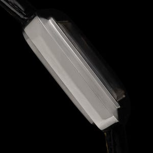 May include: Close-up of a rectangular silver wristwatch with a black leather strap. The watch has a sleek, modern design with a polished metal finish. The background is solid black, highlighting the watch's details.