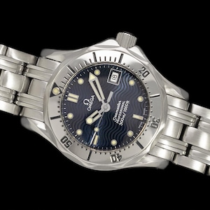 May include: A stainless steel Omega Seamaster Professional wristwatch with a blue wave-patterned dial. The watch features a date display at the 3 o'clock position and a unidirectional rotating bezel. The watch band is made of stainless steel.