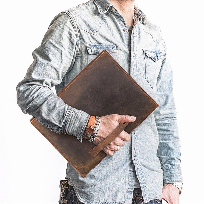 May include: A brown leather portfolio with a handle. The portfolio is distressed and has a vintage look.