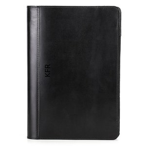 May include: Black leather binder with the initials "KFR" embossed on the front.