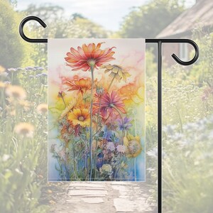 Puede incluir: Una pintura de acuarela que representa una escena de jard&iacute;n con una variedad de flores coloridas, incluyendo rojas, naranjas, amarillas y moradas. Las flores est&aacute;n dispuestas en un ramo suelto, con algunos tallos que se extienden m&aacute;s all&aacute; del marco. El fondo es una suave acuarela difuminada de azul y verde.
