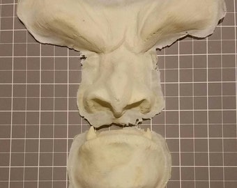 May include: Three-piece mould for creating a monster face. The mould is made of a light beige material and is designed to create a realistic-looking monster face.