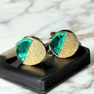 May include: A pair of gold tone cufflinks with a green glass half-circle design.