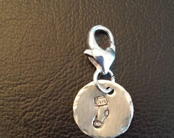 May include: Silver charm with a small sock design. The charm has a lobster claw clasp.