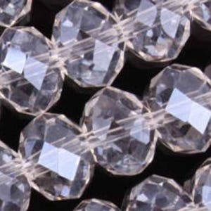 Peut inclure: Un brin de perles de verre facettées transparentes. Les perles sont rondes et ont un design facetté. Les perles sont enfilées sur un fil transparent.