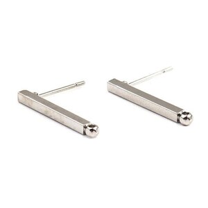 Peut inclure: Une paire de boucles d'oreilles en forme de barres argentées. Chaque boucle d'oreille présente une barre rectangulaire avec une petite boule arrondie à une extrémité et une tige pour l'insertion. Sur fond blanc.