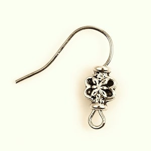 Peut inclure: Crochet d'oreille argenté avec un motif floral décoratif.