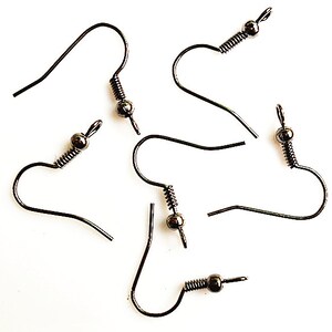 Peut inclure: Plusieurs crochets de boucles d'oreilles gris foncé sont présentés sur un fond blanc. Chaque crochet est doté d'un ressort hélicoïdal et d'une petite perle ronde. Ces crochets sont conçus pour la fabrication de bijoux et l'artisanat.