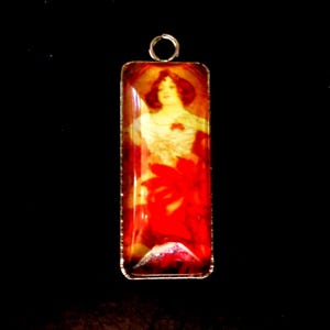 Peut inclure: Pendentif rectangulaire avec une illustration vintage d'une femme aux cheveux roux et un motif floral rouge. Le pendentif a un cadre en métal argenté et une petite boucle en haut pour une chaîne. Le fond est noir.