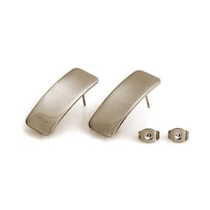 Könnte beinhalten: Ein Paar silberfarbene, gebogene Ohrstecker mit passenden Ohrringverschlüssen. Die Ohrringe haben ein schlichtes, modernes Design mit einer leicht gebogenen rechteckigen Form. Die Ohrringpfosten und -verschlüsse sind ebenfalls silberfarben.