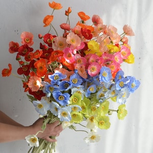 May include: A bouquet of artificial flowers with a mix of red, orange, yellow, pink, blue, and white poppy flowers.