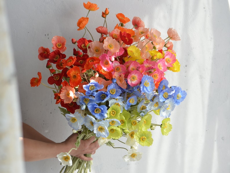 May include: A bouquet of artificial flowers with a mix of red, orange, yellow, pink, blue, and white poppy flowers.