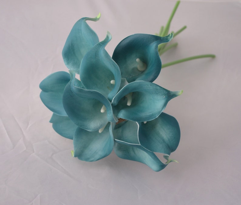 Op de afbeelding: Een boeket van teal kunstmatige calla lelies met groene stelen.