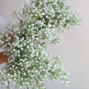 Op de afbeelding: Een boeket witte baby's breath bloemen met groene stelen.